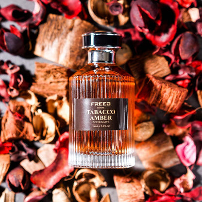 琥珀色玻璃瓶，俯視角度，乾燥花瓣場景。FREED客製化刻字。