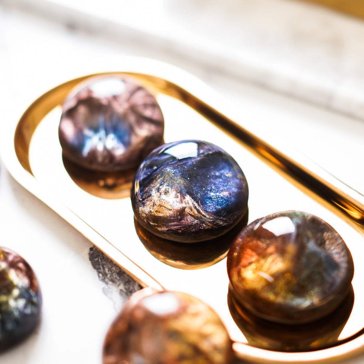 璀璨迷幻寶石手工皂，金屬光澤，俯視角度，置於金色盤中。FREED 客製化刻字。