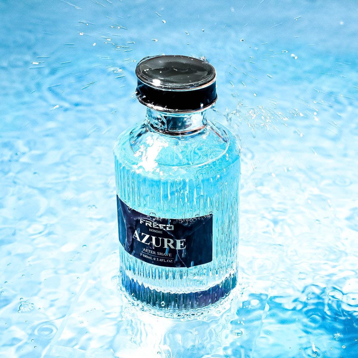 玻璃瓶裝蔚藍液體，置於水景中，FREED客製化刻字。