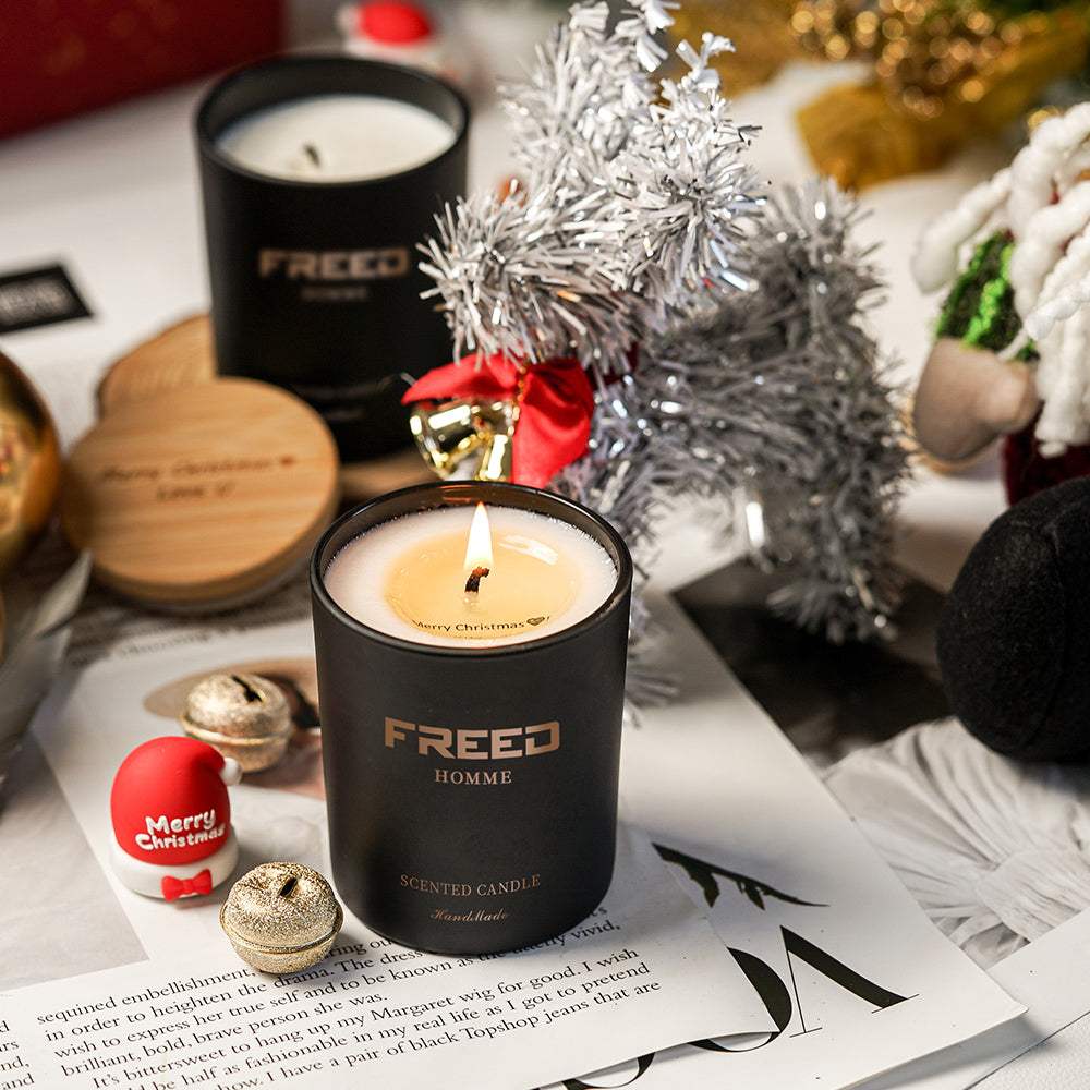 黑色大豆香氛蠟燭，點燃燭芯，溫馨節慶場景。FREED 客製化刻字。