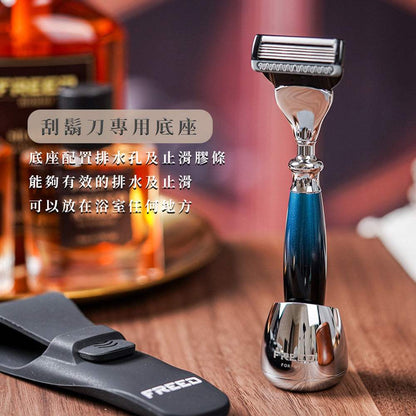 銀河藍尊爵刮鬍刀立於金屬底座，FREED 客製化刻字。