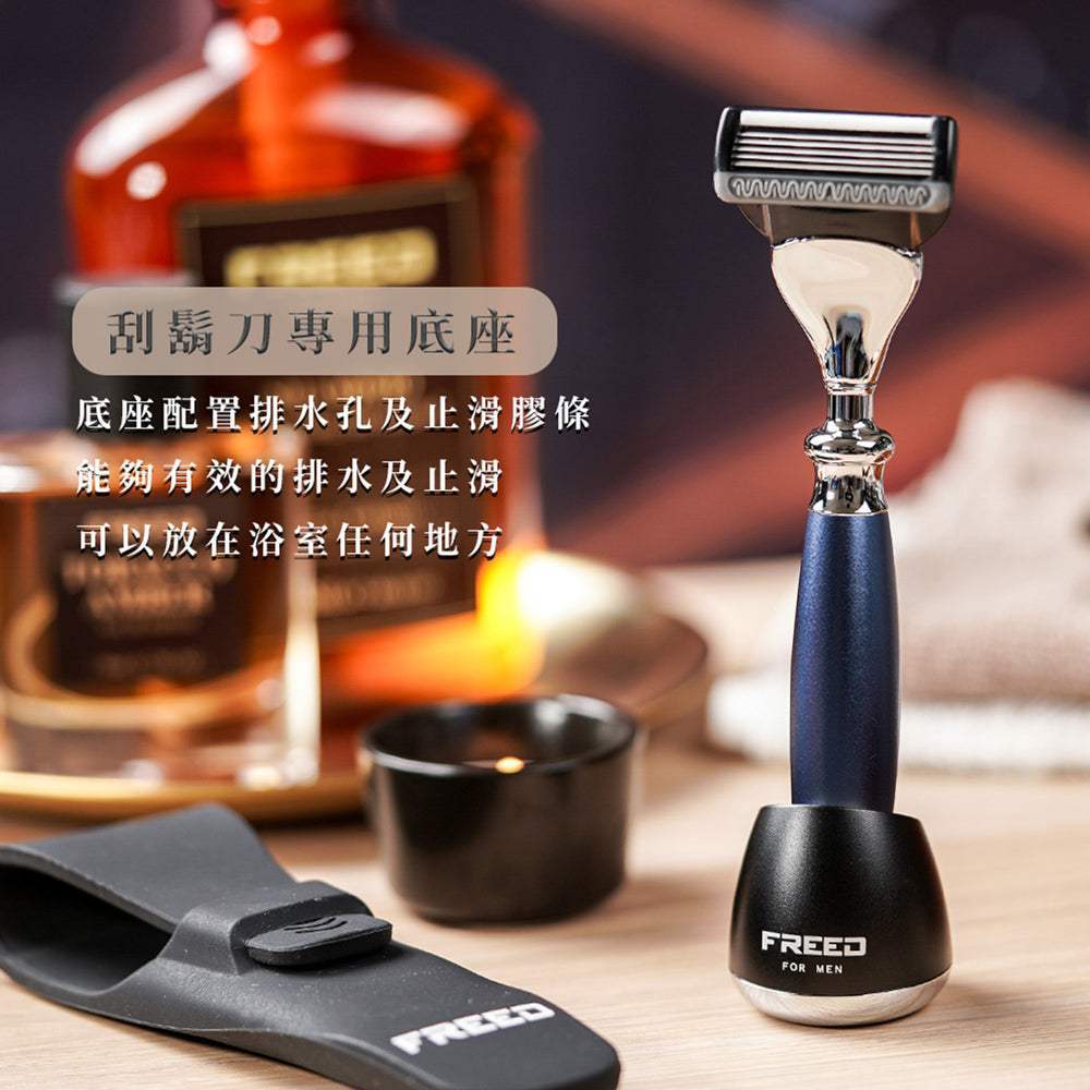 時尚藍刮鬍刀立於底座，背景為男士用品。FREED 客製化刻字。